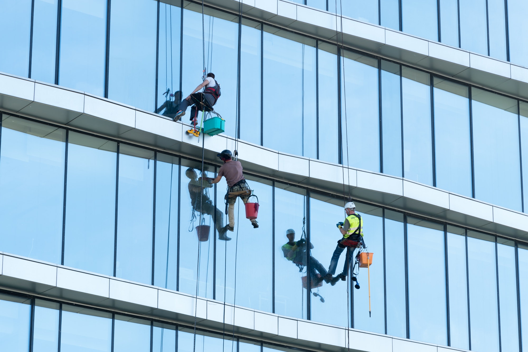 rock climbers wash the glass facade of a high-rise building